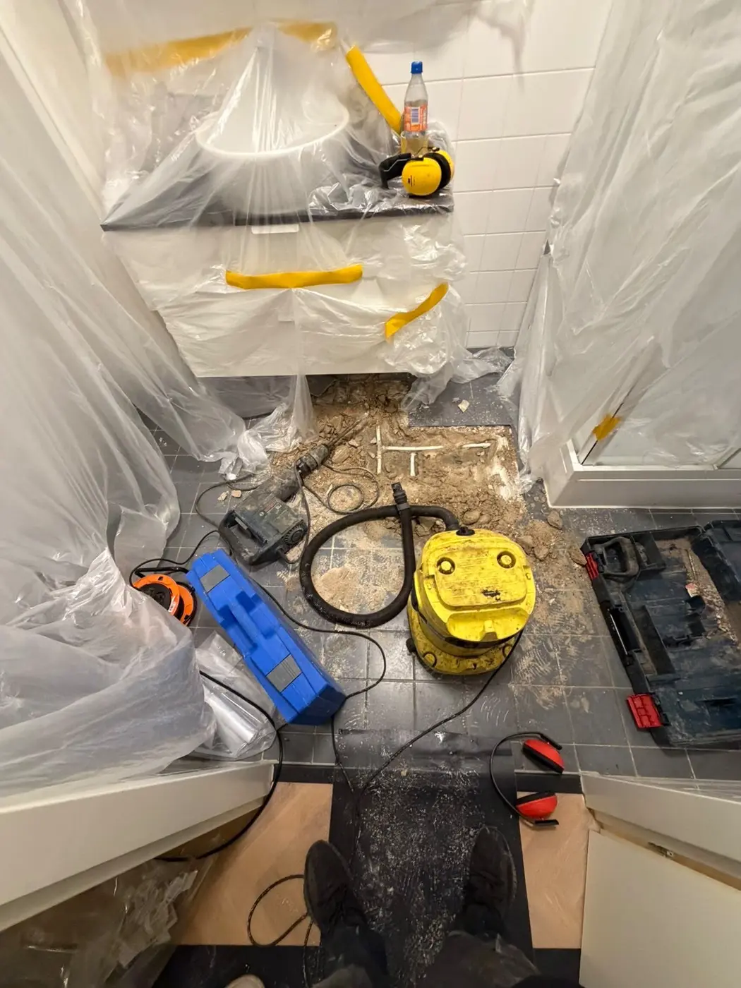 Afgeschermde badkamer met gereedschap bij een opengelegde afvoerleiding