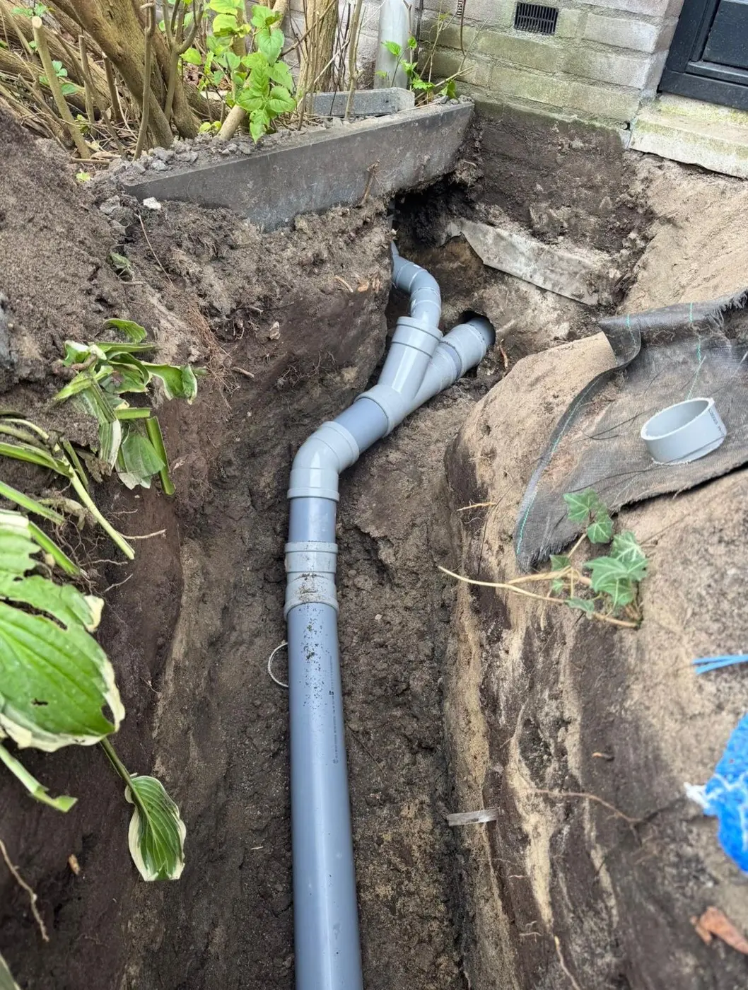 Vervangen PVC-rioolbuizen met vertakkingen in een tuin