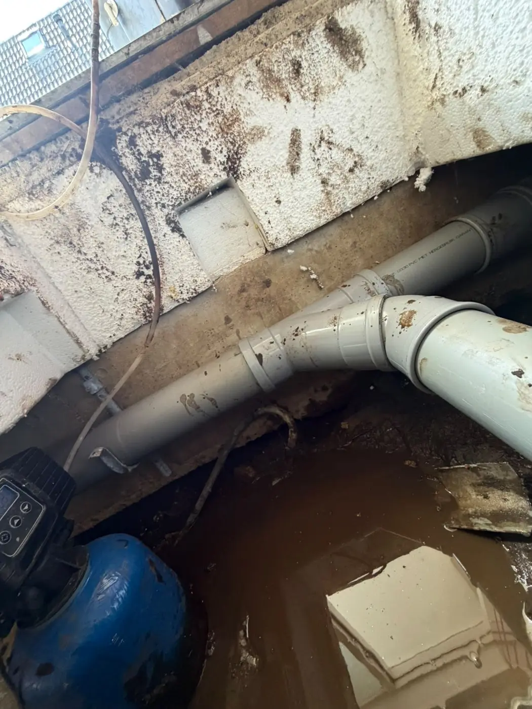 Water rond afvoerleidingen onder een geopende vloer